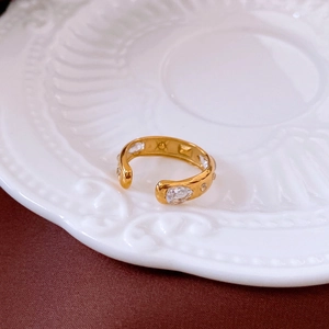 Close-up of golden adjustable ring with clear pear-cut and round zircon stones
