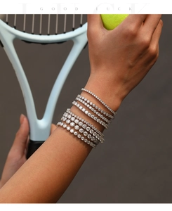 Detailopname van meerdere VVS1 moissanite tennisarmbanden om de pols met sportieve rekwisieten