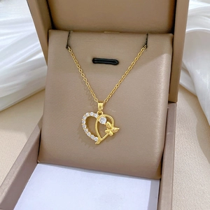 Detailed macro of gold heart and butterfly pendant with sparkling zircon in jewelry box