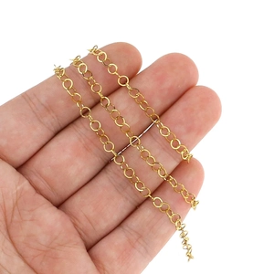 Golden stainless steel round link chain held in hand for DIY jewelry making and crafts