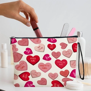 Pink heart pattern canvas makeup bag with zipper handle being filled with cosmetics