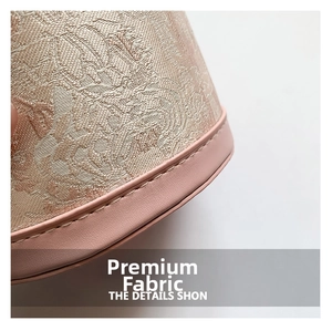 Detailed close-up of champagne floral jacquard fabric and pink leather edge stitching