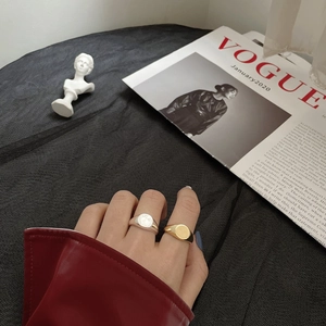 Close-up of minimalist gold and silver geometric signet rings on a model hand