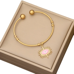Gold stainless steel evil eye cuff bracelet with a pink enamel sunburst charm