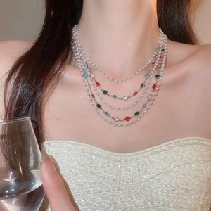 Détail du collier de perles multicouches avec pierres précieuses sur un mannequin élégant