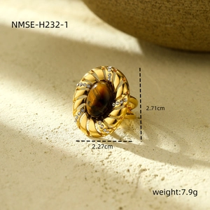 Macro view of gold-tone ring with oval tiger eye stone and crystal inlay details