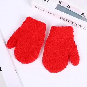 Close-up of warm red coral fleece mittens for kids with soft plush texture