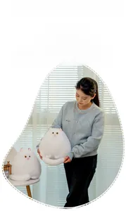 Close-up of a plush white Persian cat pillow showing soft texture and fluffy long tail