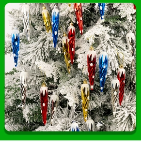 Dettaglio di pendenti a ghiacciolo colorati di Natale con neve su albero bianco