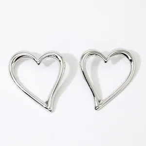 Close-up of polished silver stainless steel hollow heart earrings with thick sleek lines