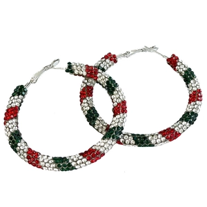 Détail de créoles scintillantes avec strass rouges, blancs et verts au motif de sucre d'orge
