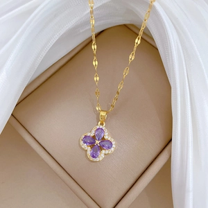 Detail of titanium steel necklace with purple amethyst flower pendant on white silk