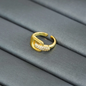 Detailed view of a gold-plated twisted ring featuring sparkling pavé diamond accents