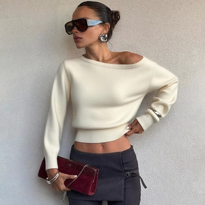 Détail d'un haut en tricot blanc cassé avec une encolure élégante à épaules dénudées