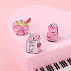 Detailed close-up of pink enamel food badges on a decorative piano surface