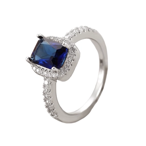 Detailed macro view of silver ring with blue square gemstone and zircon accents