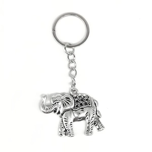 Vintage silver alloy elephant keychain with decorative textured back on white background