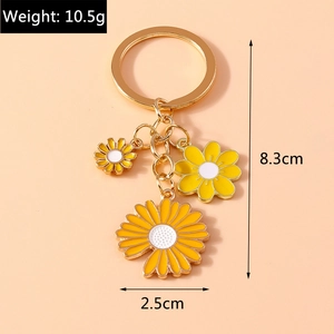 Floral golden keychain with white and yellow enamel daisies for backpack decoration