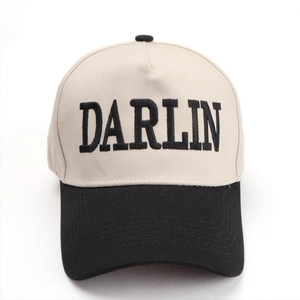 Detail of DARLIN embroidery on beige cotton crown with contrasting black brim baseball cap