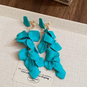 Detail of teal petal tassel earrings with matte finish and gold spiral clips for non-pierced ears