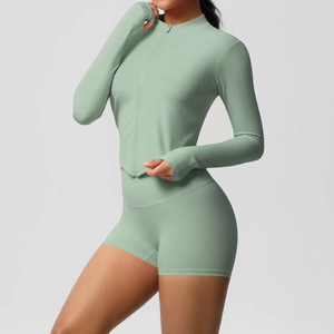Sage green fitness set detail showing thumb holes on long sleeve zipper top and high waist shorts