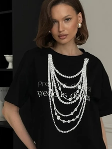 Detail of white pearl necklace print and graphic text on black cotton short sleeve T-shirt