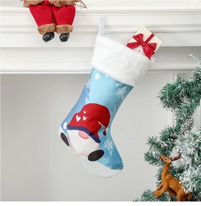 Chaussette de Noël bleue avec gnome et boîte cadeau accrochée à une cheminée blanche