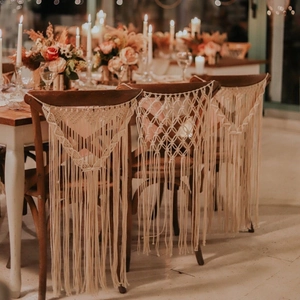 Detail of bohemian hand-woven macrame chair decorations with tassels for wedding parties