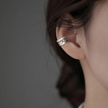 Macro view of silver layered ear cuff with irregular hammered texture on the outer ear