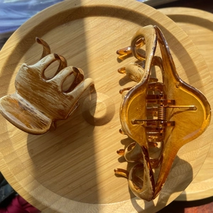 Detailed view of amber resin hair claws with oil painting texture on a bamboo tray