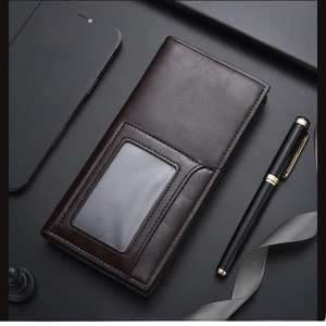 Detail of dark brown leather long wallet with ID window next to a stylish pen
