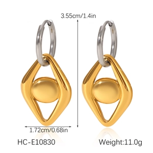Detail of gold geometric diamond earrings with silver hoops on white background