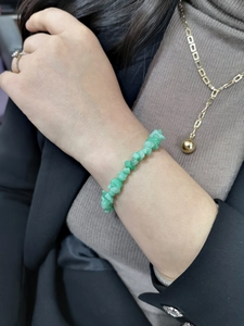 Detail of green natural irregular stone bracelet on wrist with elegant texture