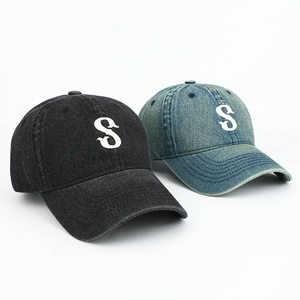 Close-up of vintage washed denim baseball caps with white letter S embroidery detail