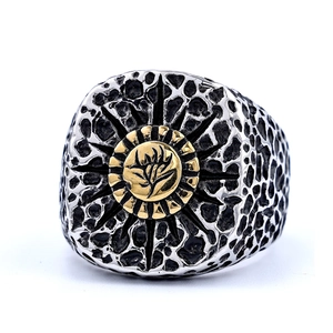 Close-up of retro punk skull ring with embossed sunburst pattern and two-tone metal finish