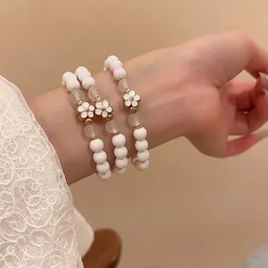 Three-piece acrylic pearl bracelet set with golden flower charms in French palace style
