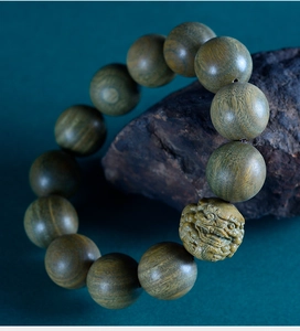 Detailed view of carved PiXiu bead on natural green sandalwood Buddhist prayer bracelet