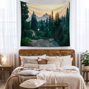 Nature tapestry with mountain and forest landscape over a bed in a cozy bedroom