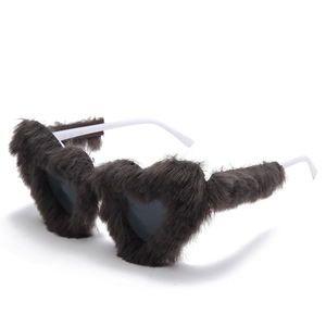 Detailed close-up of brown faux fur heart-shaped sunglasses with white plastic temples