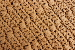 Macro shot of hand-woven paper rope texture on a vintage square summer shoulder bag