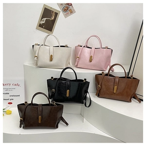 Close-up of five colorful retro faux leather tote bags with metal buckles and straps