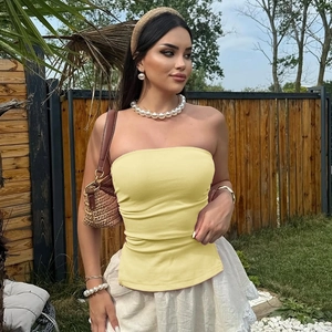 Texture détaillée du haut bandeau en maille extensible jaune citron porté par le modèle