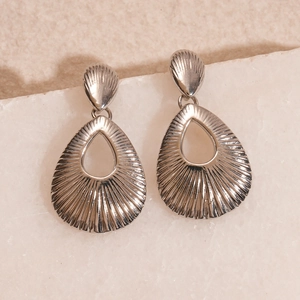 Detailed close-up of silver-tone hollow teardrop earrings with textured metal finish