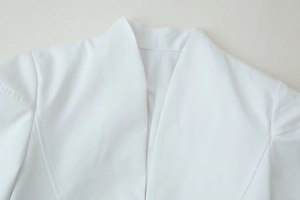Detail of V-neck collar on white professional uniform showing fine twill fabric texture
