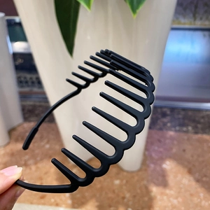 Close-up of black matte headband with wavy teeth for secure hair grip and styling