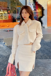 Detail of cream sherpa two-piece set featuring a cropped button jacket and mini slit skirt