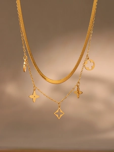 Détail du collier double rang doré avec pendentifs fleurs évidés sur chaîne serpent