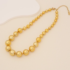 Goldene Perlenhalskette mit abgestuften Perlen und Karabinerverschluss auf elegantem Grund