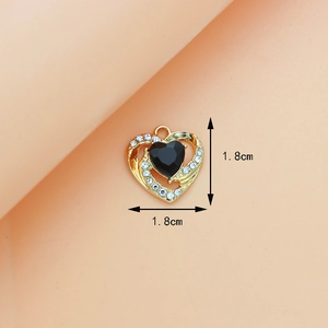 Close-up of golden heart pendant with black gemstone and white rhinestones detail
