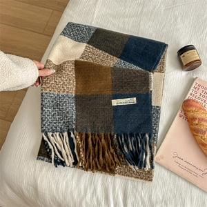 Plaid checkered scarf with fringes in beige brown and navy on a soft white bed